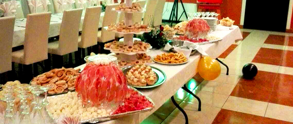 Buffet con cascata di prosciutto crudo elegante con sedie vestite nella sala principale 